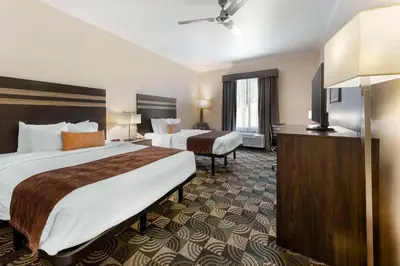 a hotel room with two beds and a flat screen tv at Best Western Plus Country Park Hotel in Tehachapi