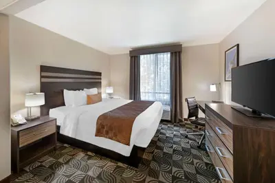 a hotel room with a bed and a flat screen tv at Best Western Plus Country Park Hotel in Tehachapi