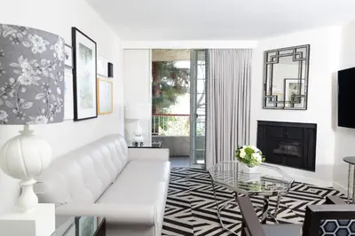 a living room with a white couch and a fireplace at Chamberlain West Hollywood in Los Angeles