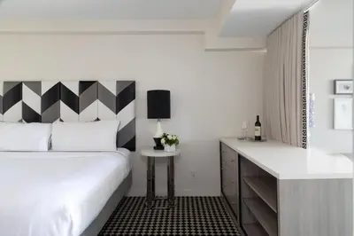 a bedroom with a white bed and a black and white headboard at Chamberlain West Hollywood in Los Angeles