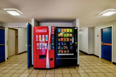 two cocacola soda machines are in a hallway at Motel 6-Hesperia, CA - West Main Street I-15 in Hesperia