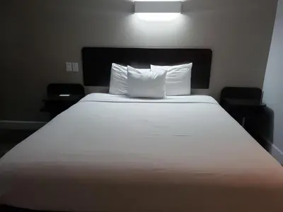 a large white bed with two pillows in a room at Motel 6-Hesperia, CA - West Main Street I-15 in Hesperia