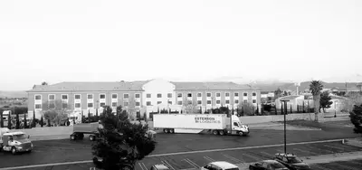 a truck in a parking lot in front of a large building at Motel 6-Hesperia, CA - West Main Street I-15 in Hesperia