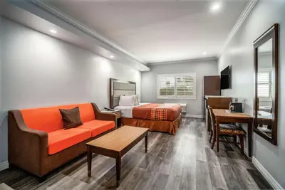 a hotel room with a bed and a couch at Rodeway Inn & Suites Pasadena in Pasadena