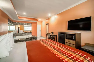 a hotel room with a bed and a flat screen tv at Rodeway Inn & Suites Pasadena in Pasadena