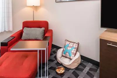 a living room with a red couch and a chair at TownePlace Suites by Marriott San Bernardino Loma Linda in Loma Linda