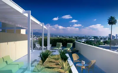 a patio with chairs and tables on a balcony at Avalon Hotel Beverly Hills, a Member of Design Hotels in Los Angeles