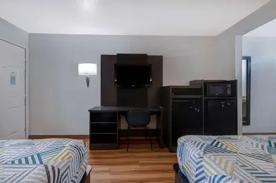 a hotel room with two beds and a desk with a television at Motel 6-Buttonwillow, CA Central in Buttonwillow