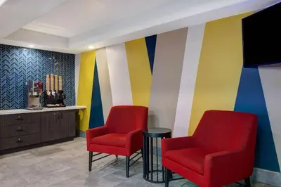 a waiting room with two red chairs and a colorful wall at Motel 6-Buttonwillow, CA Central in Buttonwillow