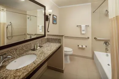 a bathroom with a sink and a toilet and a mirror at DoubleTree by Hilton Claremont in Claremont