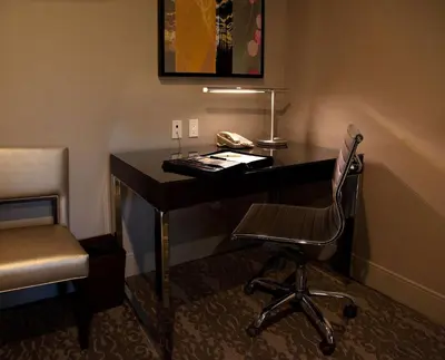 a desk in a room with a chair and a phone at DoubleTree by Hilton Claremont in Claremont