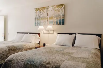 a bedroom with two beds and a painting on the wall at Vintage Lakeside Inn in Big Bear Lake