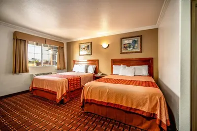 a hotel room with two beds and a window at Regency Inn & Suites Downey in Downey