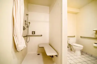 a bathroom with a toilet and a shower at Regency Inn & Suites Downey in Downey