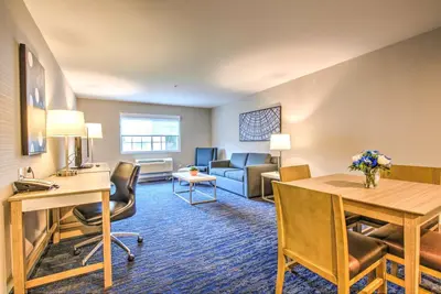 a hotel room with a desk and a living room at Best Western Plus Media Center Inn & Suites in Burbank
