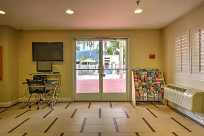 a room with a television and a desk with a computer at Burbank Inn and Suites in Burbank