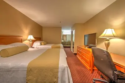 a hotel room with two beds and a television at Burbank Inn and Suites in Burbank