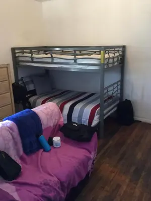 a bedroom with two bunk beds and a chair at Timen House in North Hollywood