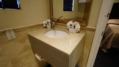 a bathroom with a sink with towels on it at Trylon Hotel - Hollywood in Los Angeles