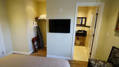 a room with a bed and a television on a wall at Trylon Hotel - Hollywood in Los Angeles