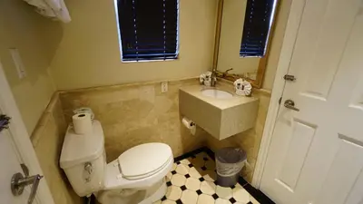 a bathroom with a white toilet and a sink at Trylon Hotel - Hollywood in Los Angeles