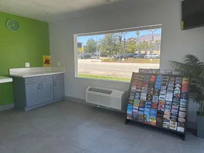 a room with a window and a book shelf with books at Hi-Way Host Motel in Pasadena