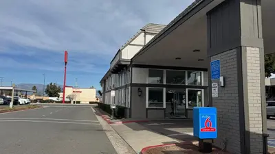 a building with a parking meter next to a street at Studio 6 Corona, CA West in Corona