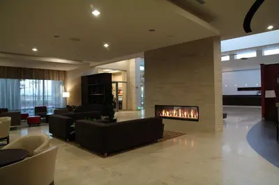a lobby with couches and a fireplace in a building at Embassy Suites Ontario - Airport in Ontario