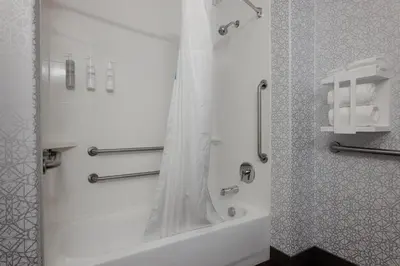 a bathroom with a tub and a shower with a mirror at Hampton Inn & Suites Palmdale in Palmdale