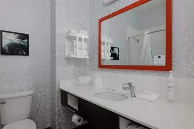 a bathroom with a toilet and a sink with a mirror at Hampton Inn & Suites Palmdale in Palmdale