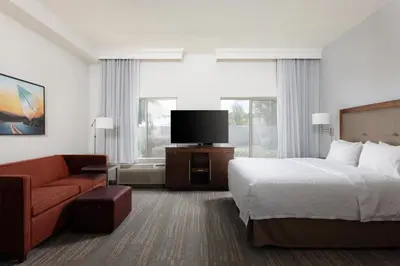 a hotel room with a bed and a flat screen tv at Hampton Inn & Suites Palmdale in Palmdale