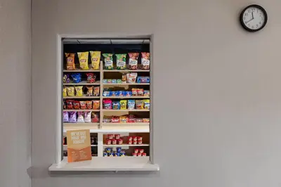 a clock on a wall next to a shelf with food at Hampton Inn & Suites Palmdale in Palmdale
