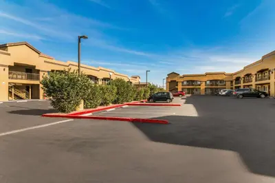 a parking lot with a red curb in front of a building at Econo Lodge Hesperia - Victorville I-15 in Hesperia