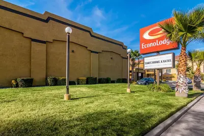 a front of a hotel with a sign and a palm tree at Econo Lodge Hesperia - Victorville I-15 in Hesperia