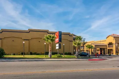 a large building with palm trees in front of a street at Econo Lodge Hesperia - Victorville I-15 in Hesperia