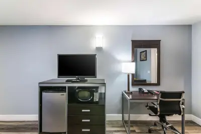 a room with a tv and a desk with a computer at Econo Lodge Hesperia - Victorville I-15 in Hesperia