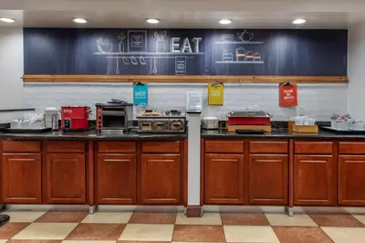 a kitchen with wooden cabinets and a counter top at Hampton Inn Norco/Corona in Norco