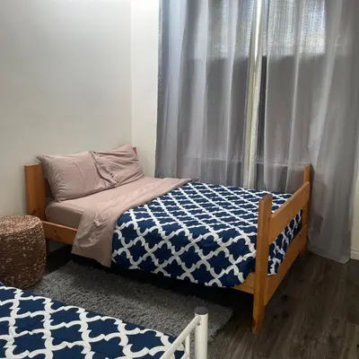 a bedroom with a bed with a blue and white comforter at Beautiful 4BD and 3BA Pool Jacuzzi Vacation Home in Los Angeles
