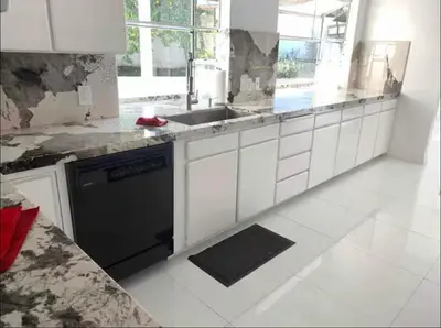 a kitchen with white cabinets and a black dishwasher at Beautiful 4BD and 3BA Pool Jacuzzi Vacation Home in Los Angeles