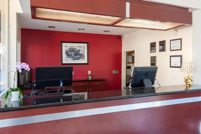an office with a reception desk with a red wall at Studio City Court Yard Hotel in Los Angeles
