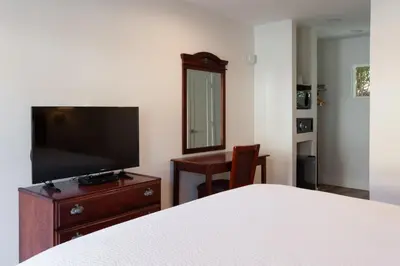 a bedroom with a bed and a flat screen tv at Studio City Court Yard Hotel in Los Angeles