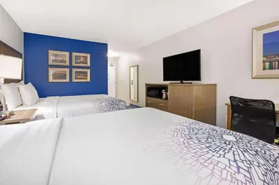 a hotel room with two beds and a flat screen tv at La Quinta by Wyndham NE Long Beach/Cypress in Hawaiian Gardens