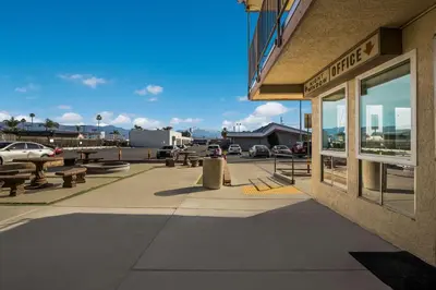a building with benches on a sidewalk next to a street at Rodeway Inn San Bernardino - Colton in San Bernardino