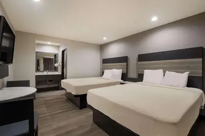 a hotel room with two beds and a television at Rodeway Inn San Bernardino - Colton in San Bernardino