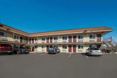a large building with cars parked in a parking lot at Rodeway Inn San Bernardino - Colton in San Bernardino