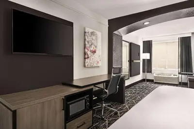 a hotel room with a desk and a flat screen tv at La Quinta by Wyndham Hesperia Victorville in Hesperia