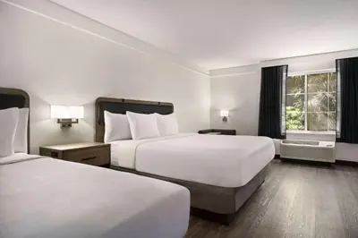 a hotel room with two beds and a window at La Quinta by Wyndham Hesperia Victorville in Hesperia