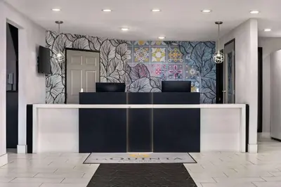 a lobby with a reception desk in front of a wall at La Quinta by Wyndham Hesperia Victorville in Hesperia