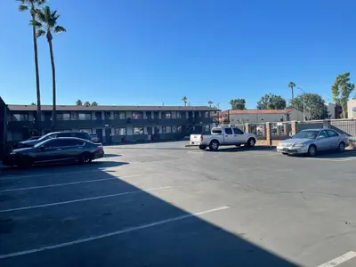 a parking lot with cars parked in front of a building at Studio 6 Suites San Bernardino, CA in San Bernardino