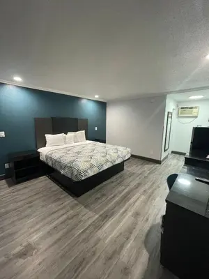 a bedroom with a bed and a blue wall at Studio 6 Suites San Bernardino, CA in San Bernardino